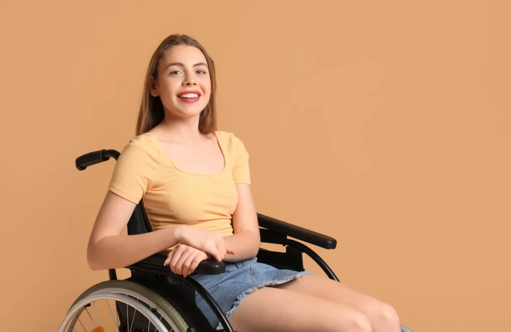 Happy disabled woman in wheelchair smiling at camera
